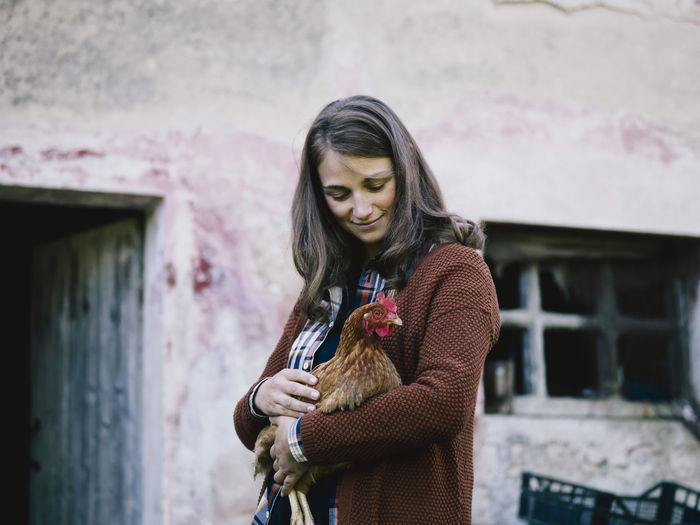 Smiling woman with chicken