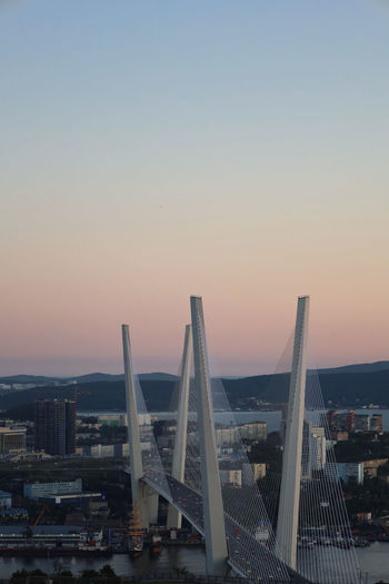 View of bridge and buildings against sky during sunset