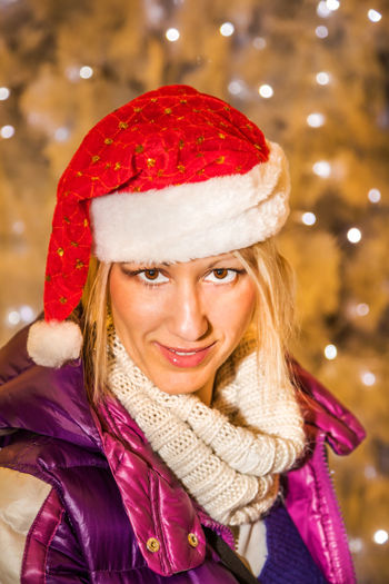 Portrait of smiling mature woman wearing santa hat during christmas