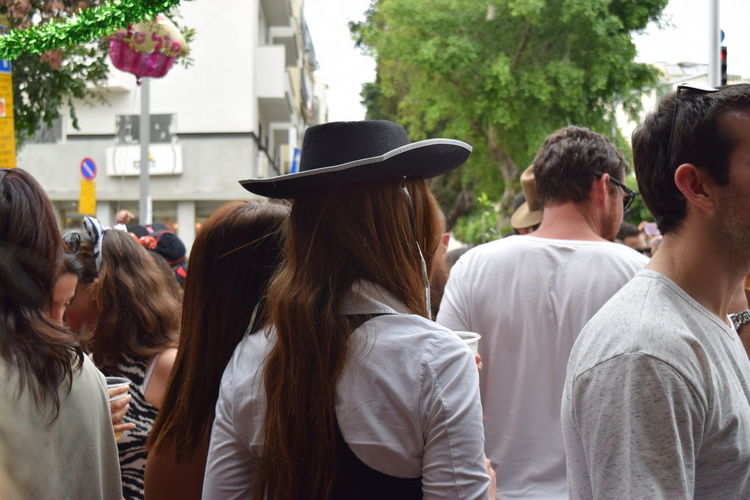 Rear view of people on street party standing outdoors wearing customs