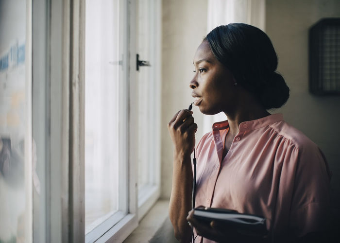 YOUNG WOMAN LOOKING AWAY AT WINDOW