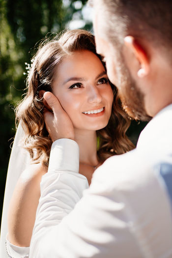 Close-up of bridegroom embracing outdoors