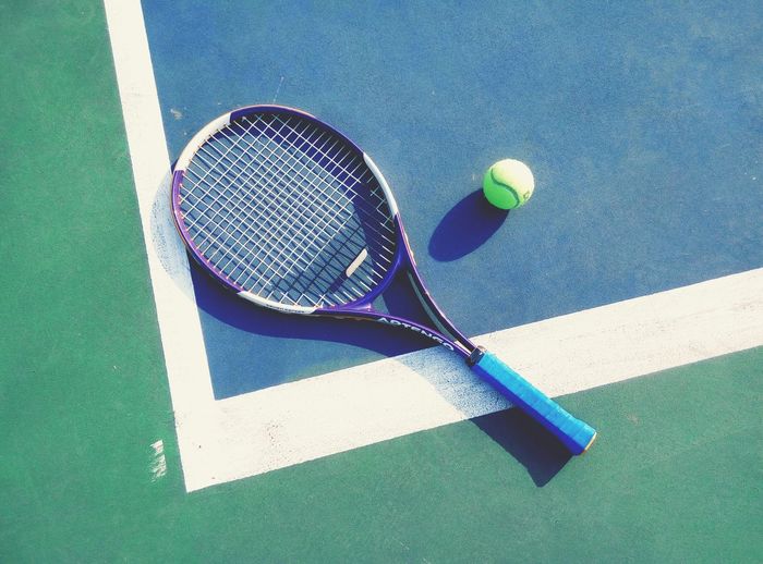 High angle view of tennis racket and ball on playing field