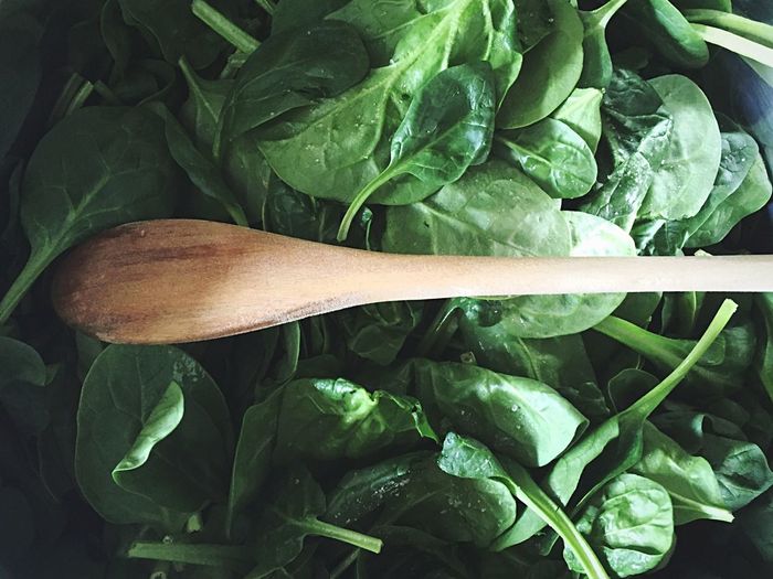 Directly above shot of wooden spoon on spinach