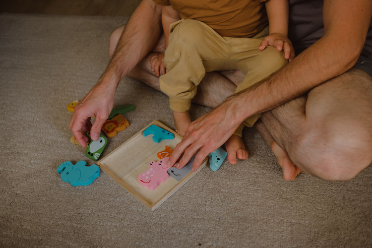 Cropped hands of man playing with toy blocks