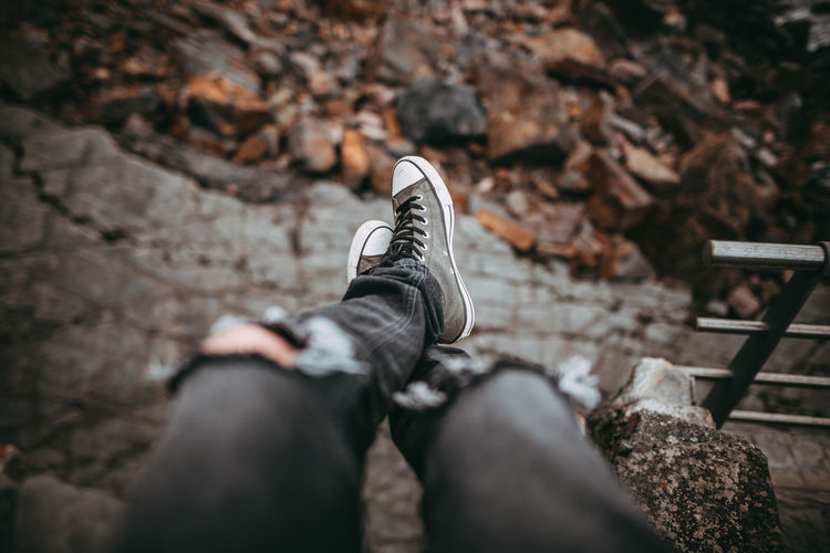 Low section of person wearing canvas shoe against field