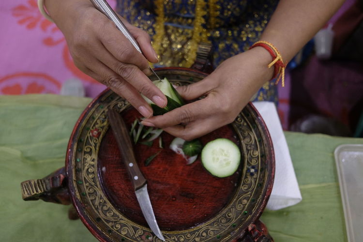 Cropped hands of woman carving on food