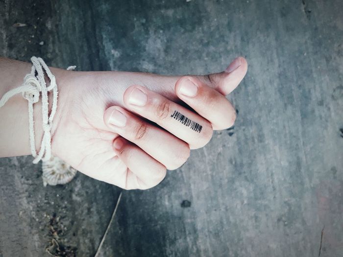 Cropped image of person with barcode on finger at table