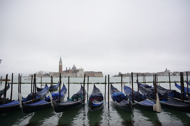 Gondolas on grand canal against sky in city
