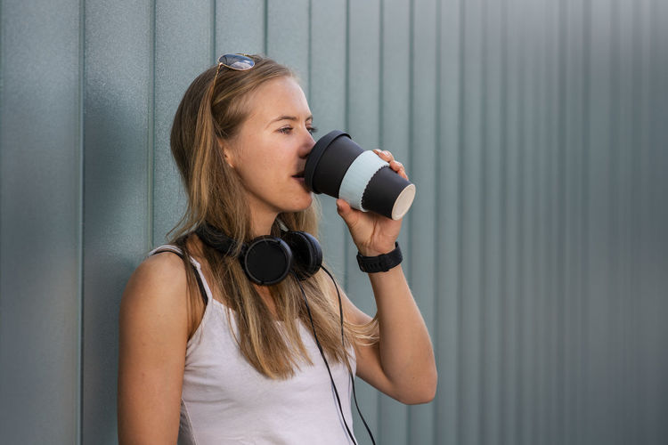 Young woman drinking coffee to go