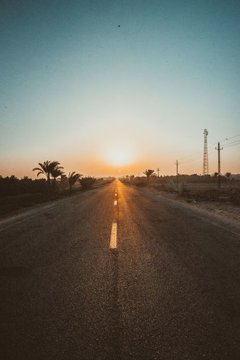 Road against clear sky during sunset