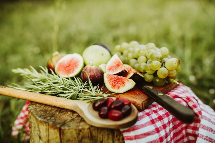 Close-up of fruits on cutting board with plants in background