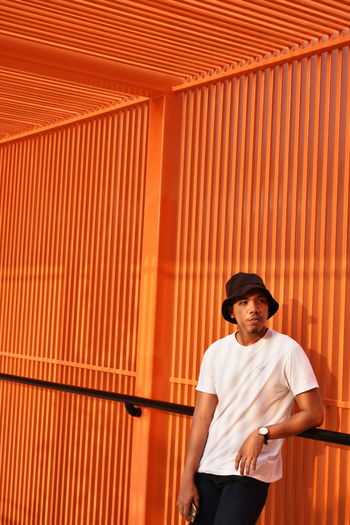Man standing against orange wall