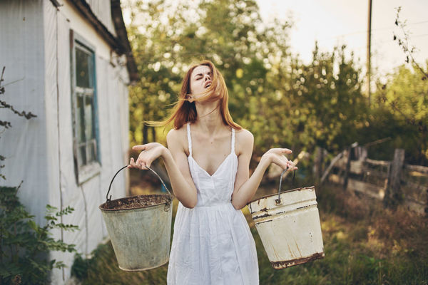 Young woman standing against plants