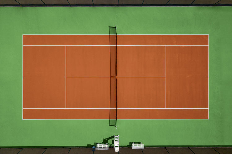 Aerial view of orange and green tennis hard court.