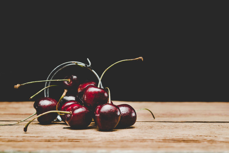Close-up of cherries on table against black background