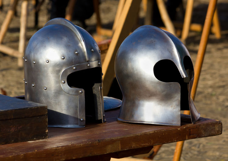 Close-up of old helmets on table outdoors