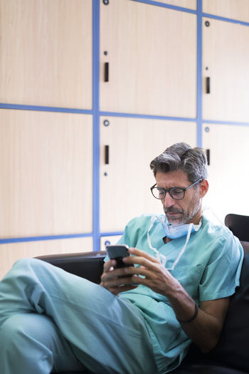 Surgeon sitting and using smartphone