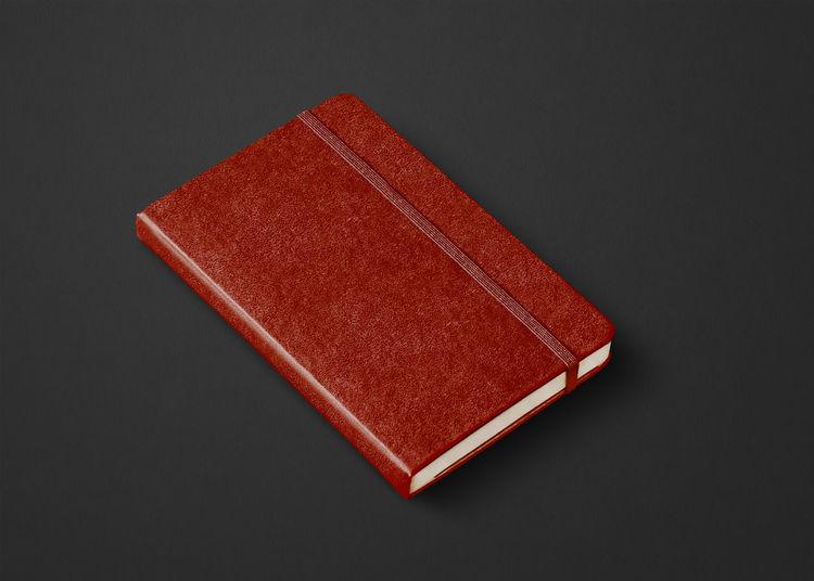 High angle view of red book on table against black background