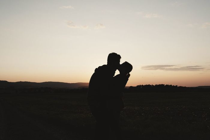 Silhouette couple kissing against clear sky