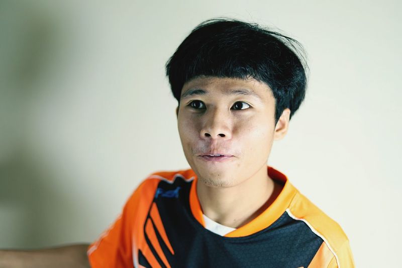 Young man looking away against white background