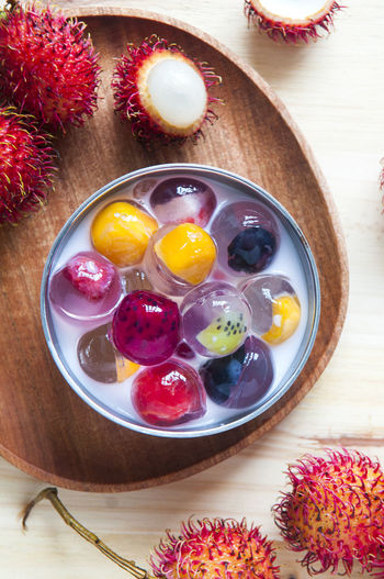 High angle view of fruit jelly and rambutans on table