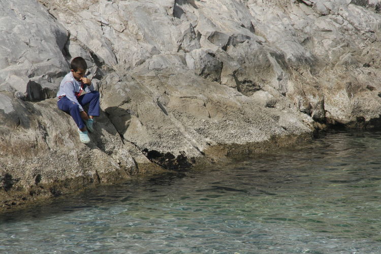Full length of man on rock at shore