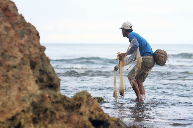 Man throwing fishing net in the sea