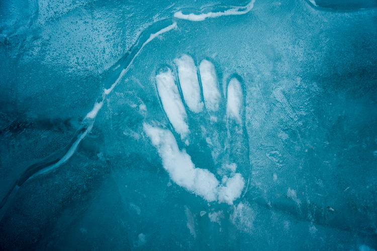 Hand print on the blue ice