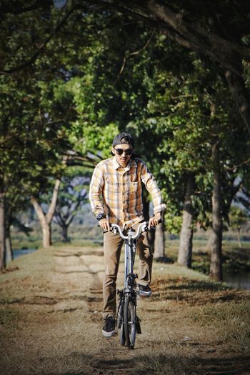 Portrait of man riding brompton folding bicycle on tree