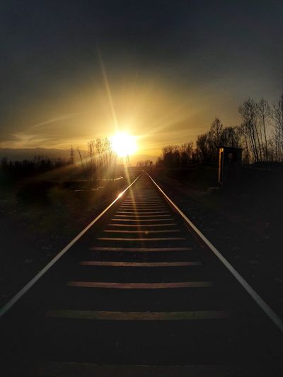 Railroad tracks against sky during sunset