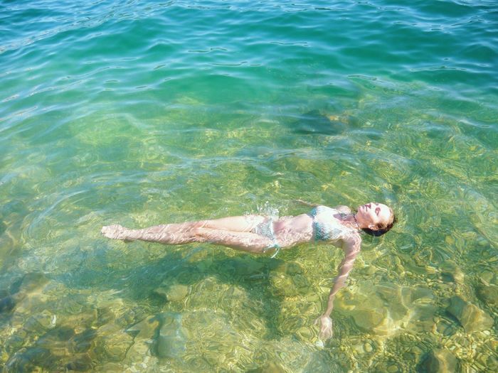 High angle view of young woman swimming in sea