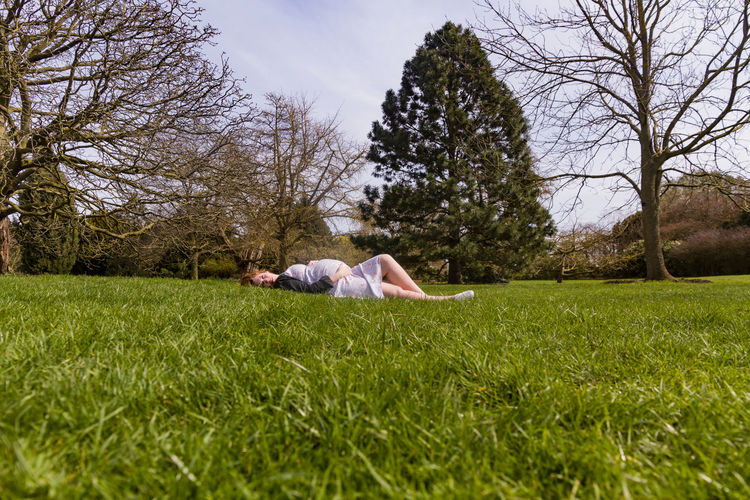Pregnant woman lying at park