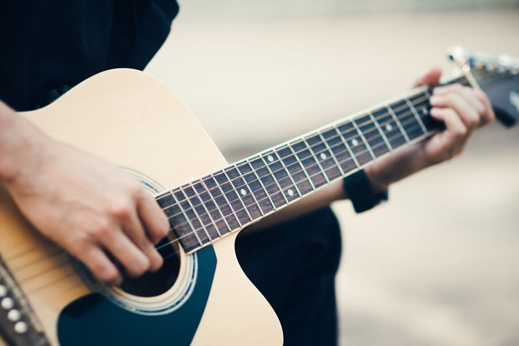Cropped image of street musician playing guitar