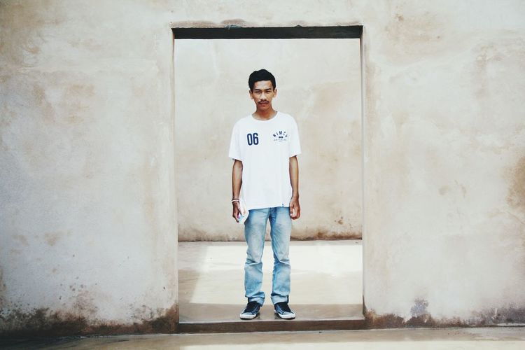 Portrait of young man standing at door 