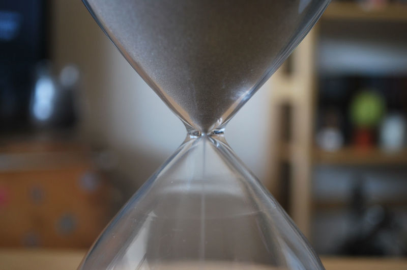 Close-up of sunlight falling on glass sand timer 