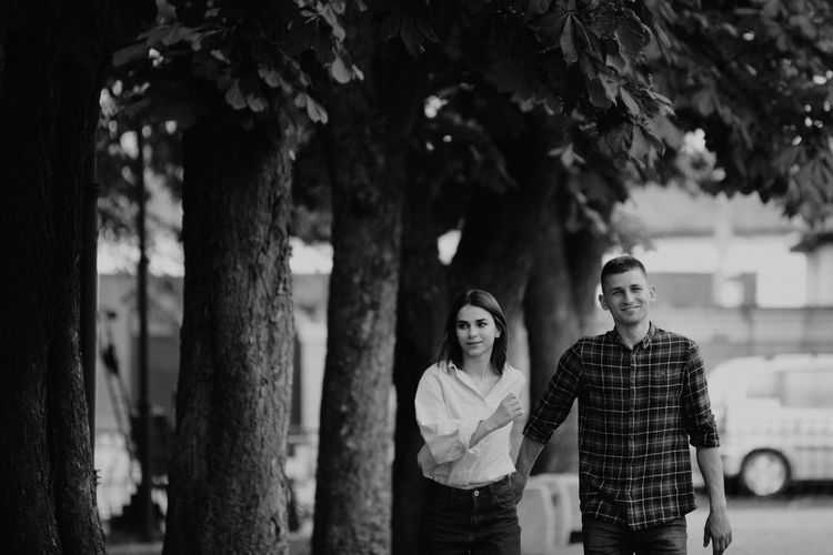 Couple walking together by trees in city