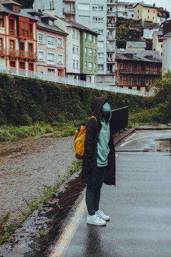 Rear view of man walking on street in city
