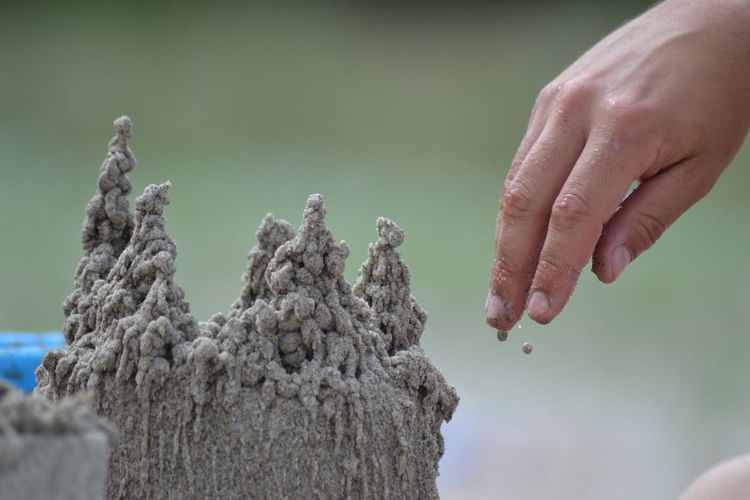 Cropped hand making sandcastle