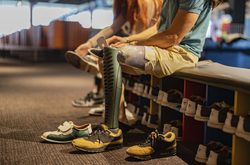 Man with prosthetic leg wearing bowling shoes at alley