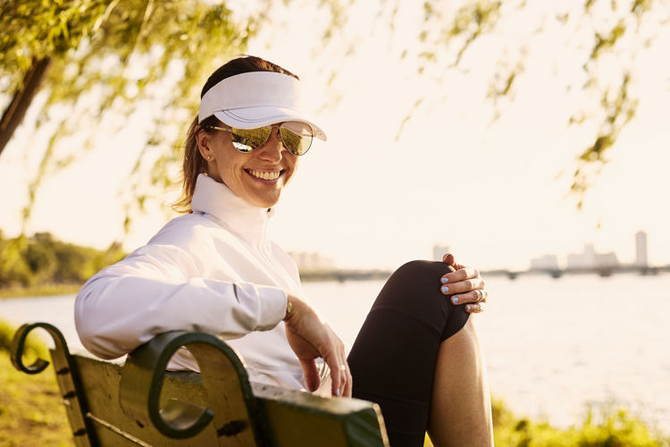 A portrait of a woman on a bench next to the charles river.