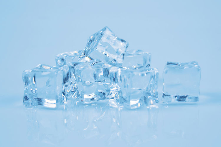Stack of ice cubes on blue background