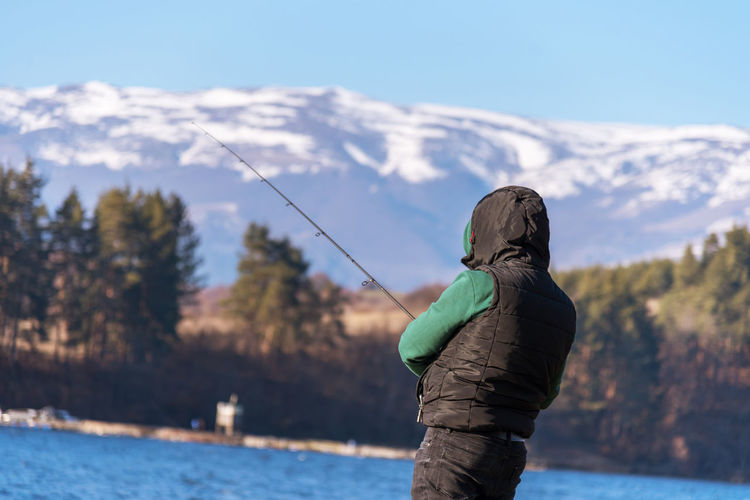 Angler catching the fish at autumn day.