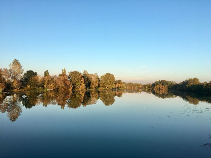 Scenic view of lake against clear blue sky