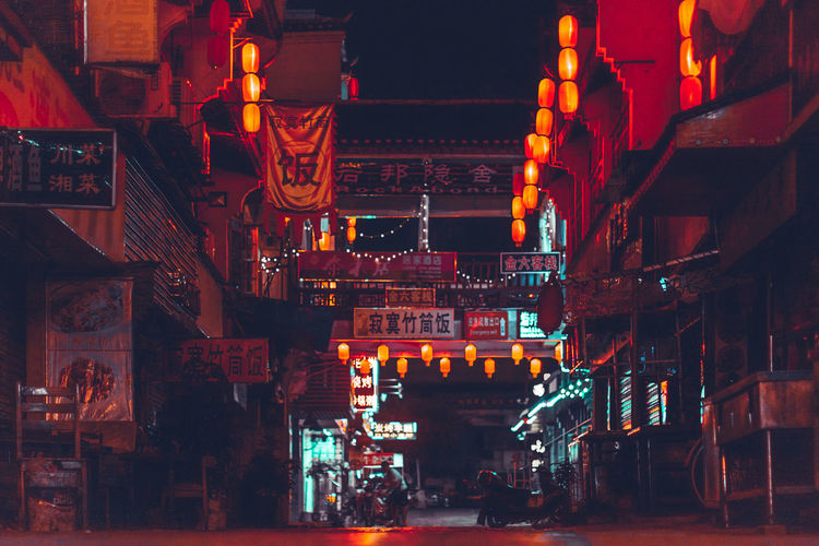 Illuminated lanterns hanging by building in city at night