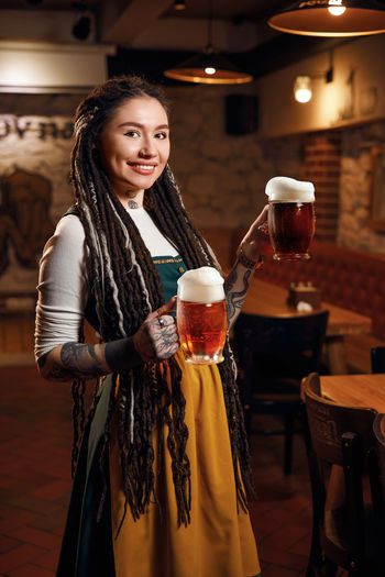 A waitress with two pints of beer in her hand in a beer pub
