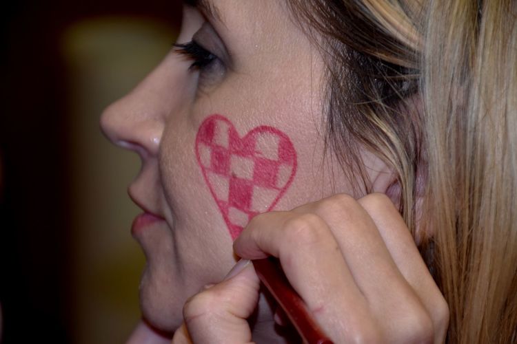 Close-up of woman making heart shape on cheek