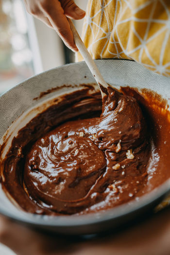 Close-up of person making chocolate  cake