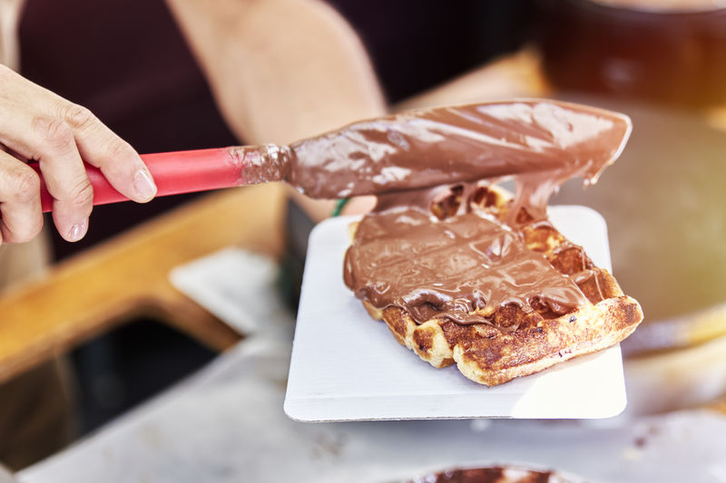 Unrecognizable person preparing a delicious chocolate waffle. concept sweet food, dessert