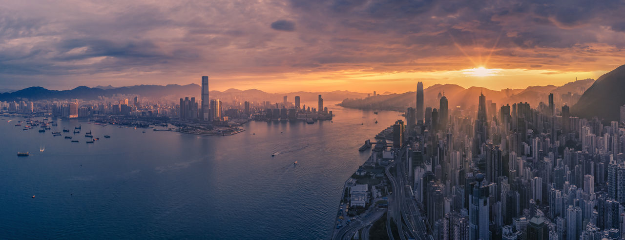 Panoramic view of harbour and city against sky during sunrise